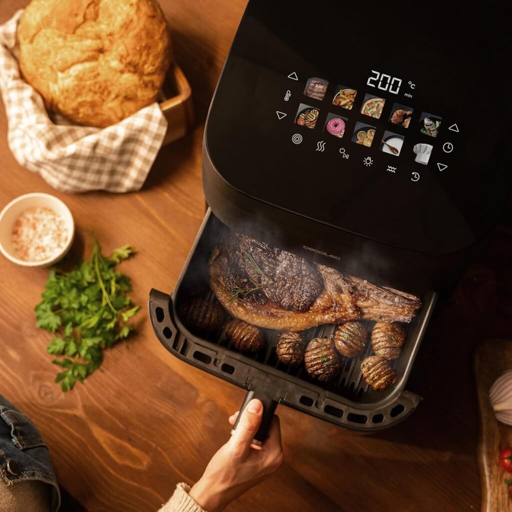 Freidora de aire Cecotec Smokin'Heat 4000 abierta con bistec y patatas asadas en su interior, lista para servir en una cocina cálida y rústica