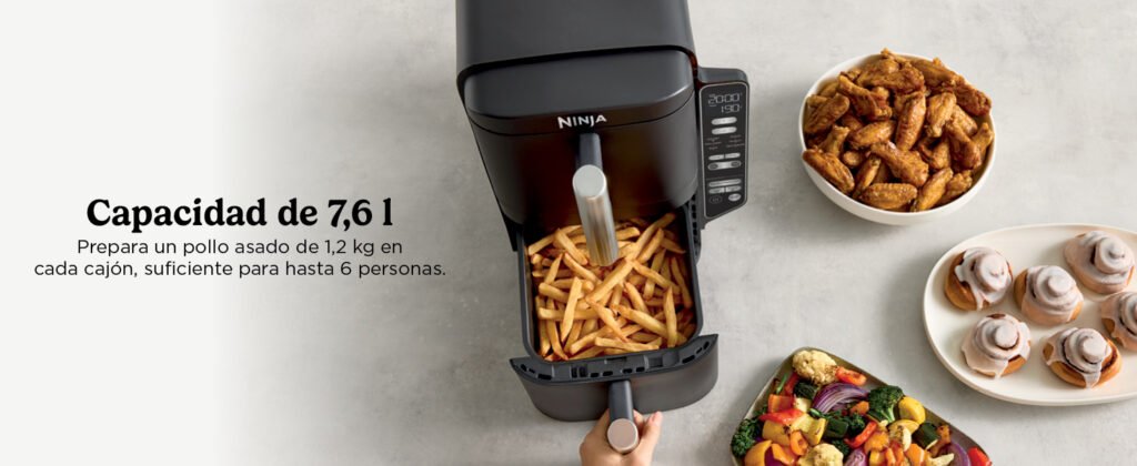 Vista superior de la freidora Ninja SL300EU con un cajón abierto lleno de patatas fritas y platos alrededor